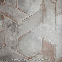 a close up view of a tile floor with grey and white colors on the tiles