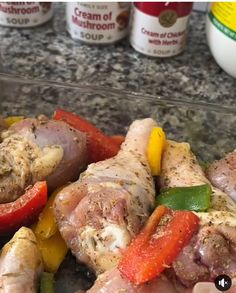 chicken and peppers are on the counter next to yogurt bottles with sauces in the background