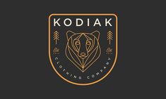 the kodiak clothing company logo is shown in gold and black on a dark background