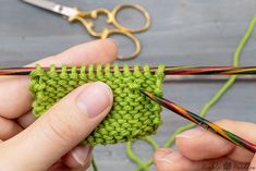 two hands are working on a green crochet stitch