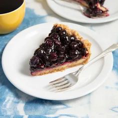 a slice of blueberry pie on a plate with a fork