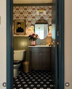 an open door leading to a bathroom with a painting on the wall and a toilet