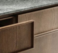 a close up of a counter top with two drawers and a marble top in the middle