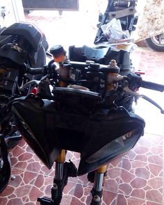 two motorcycles parked next to each other on a tile floor