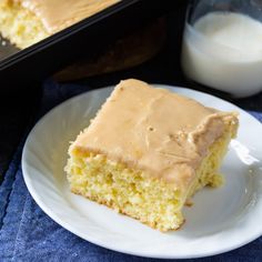 a piece of cake sitting on top of a white plate next to a glass of milk