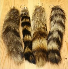 four different colored furry animal tails hanging from hooks