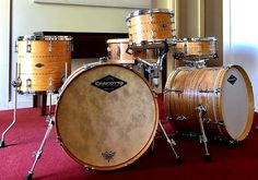 a drum set sitting on top of a red carpeted floor next to a wall