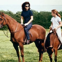 two women are riding horses in a field