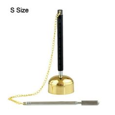 a pen is sitting on top of a gold bell with a chain around the neck