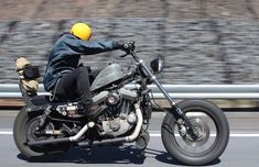 a man riding on the back of a motorcycle down a road