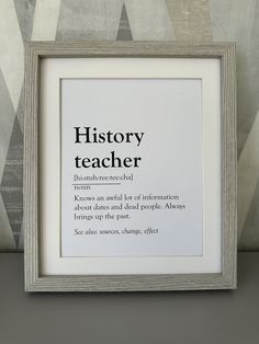 a framed poster with the words history teacher in black and white on it, next to a wallpapered background