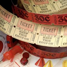 two rolls of red and yellow tickets sitting next to each other on top of a table