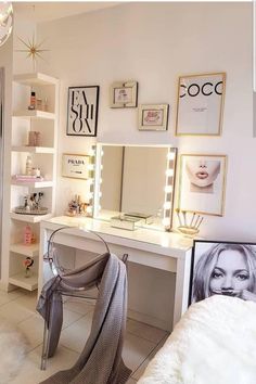 a white vanity with lights and pictures on the wall