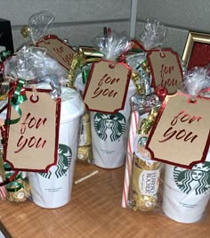 starbucks coffee cups decorated with christmas decorations and candy canes are on the table for sale