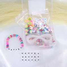 a plastic bag filled with different types of buttons and beads next to a rubber bead bracelet