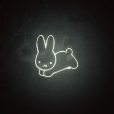 a neon sign with a rabbit laying down on it's side in the dark