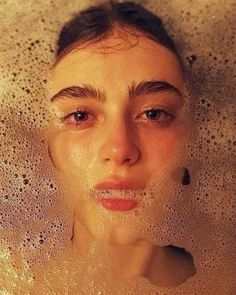 a woman is taking a bubble bath in the tub with bubbles on her face and nose