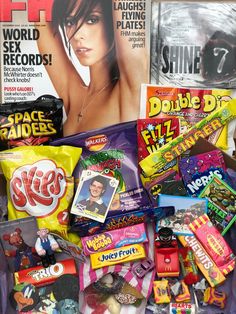 a pile of assorted candy on top of a table next to a magazine cover