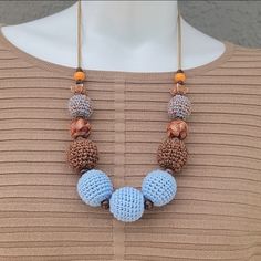 a blue and brown beaded necklace on top of a mannequin's torso