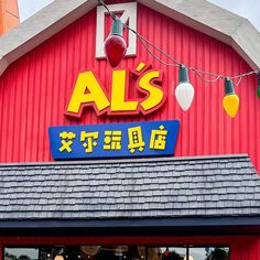 a red building with lights hanging from it's roof and the word als written in chinese