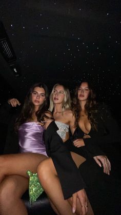 three beautiful women sitting next to each other in front of a star filled night sky