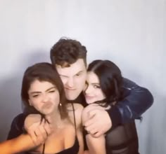 three people are hugging and posing for the camera