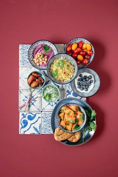 a table topped with plates and bowls filled with food