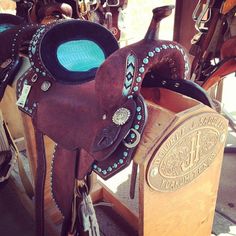 there are many different types of saddles in this photo, including one with a turquoise light on it