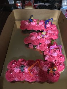 pink cupcakes in a cardboard box with decorations