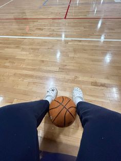 a person with their feet on a basketball