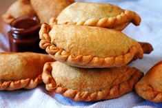 several pastries stacked on top of each other with dipping sauce in the back ground