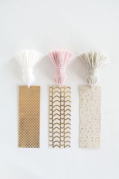 three bookmarks with different patterns on them, one is gold and the other is white