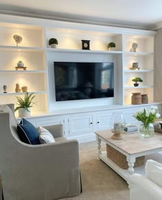 a living room filled with furniture and a flat screen tv mounted on a wall above a fireplace