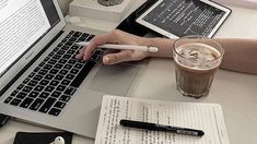 a person sitting in front of a laptop computer with a pen and paper on it