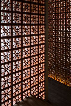 a room divider made out of wood with intricate designs on the wall and floor