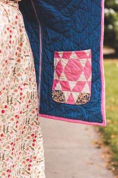 a woman is holding a quilt on her arm