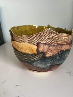 three bowls with different designs on them sitting on a white counter top next to a black box