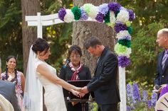 a bride and groom holding hands at their wedding ceremony in front of an outdoor altar