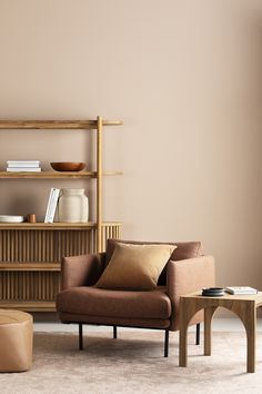 a living room filled with furniture and a book shelf next to a coffee table on top of a carpeted floor