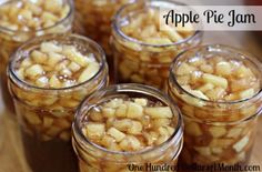 jars filled with apple pie jam sitting on top of a wooden table