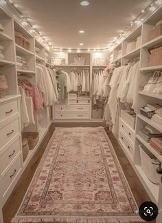 a walk in closet filled with lots of clothes and rugs on top of shelves