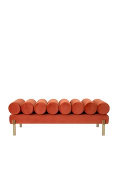 an orange couch with gold legs and pillows on it's back end, against a white background