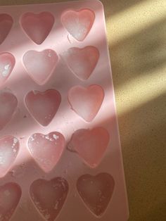 heart shaped ice cubes sitting on top of a pink tray