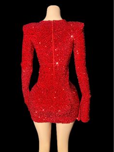 a mannequin wearing a red dress with sequins on the shoulders and long sleeves