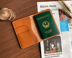 a passport case sitting on top of a wooden table next to a wheat seed and a paper