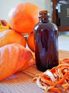 an orange peel is on the cutting board next to a bottle of juice and some fruit