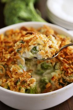 a white bowl filled with broccoli casserole on top of a table