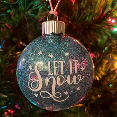 a christmas ornament that says let it snow on the front of a tree