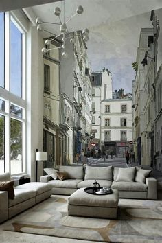 a living room filled with lots of furniture next to a large wallpapered mural