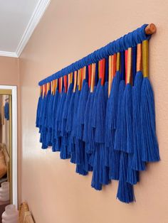 a wall hanging with tassels on it in a hallway or dining room area